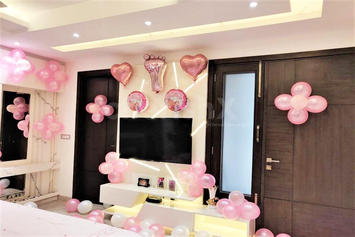 CherishX Welcome baby girl decor includes an arc of balloons at the entrance.