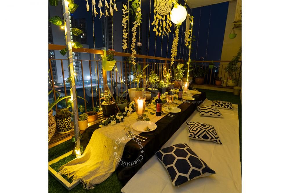 Low Dining Tables decorated with 2 Golden Vase filled with White Flower Bunches and a Golden Lamp placed on the table for the Boho Dining Experience.