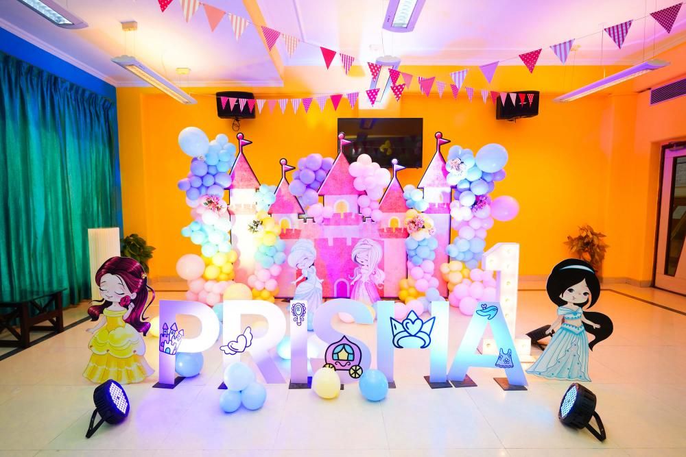 Our princess-themed decor features a captivating castle backdrop adorned with pastel balloons, creating an enchanting arch.