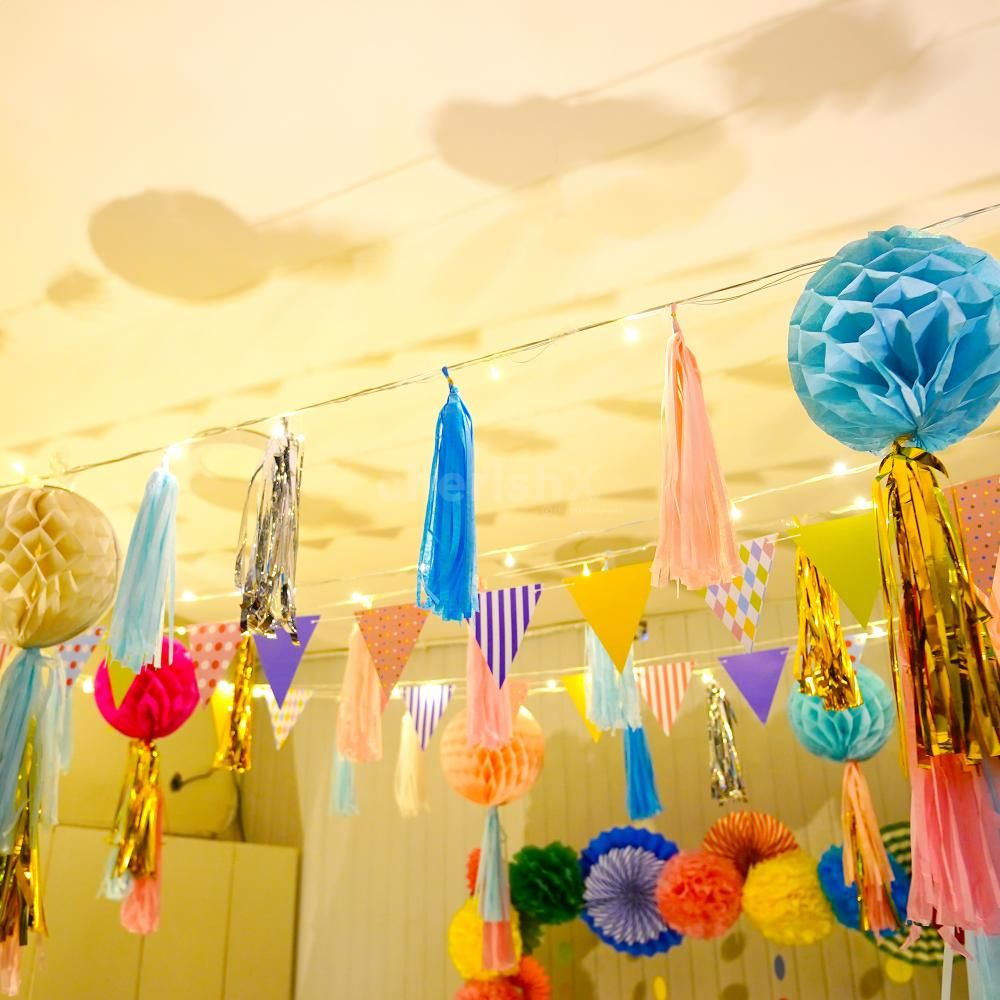 Close-up of colourful honeycomb balls adorned with festive tassels.