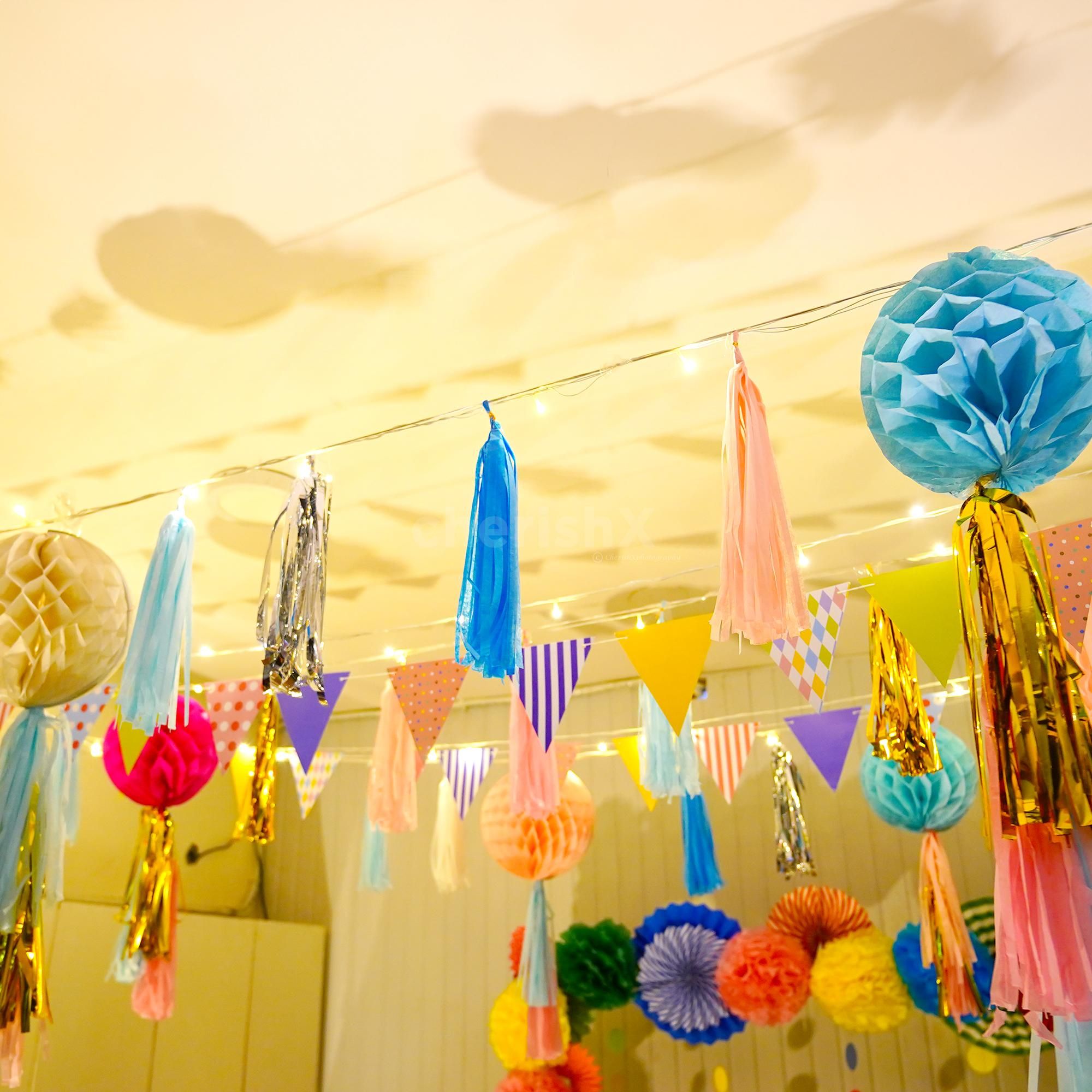 Close-up of colourful honeycomb balls adorned with festive tassels.