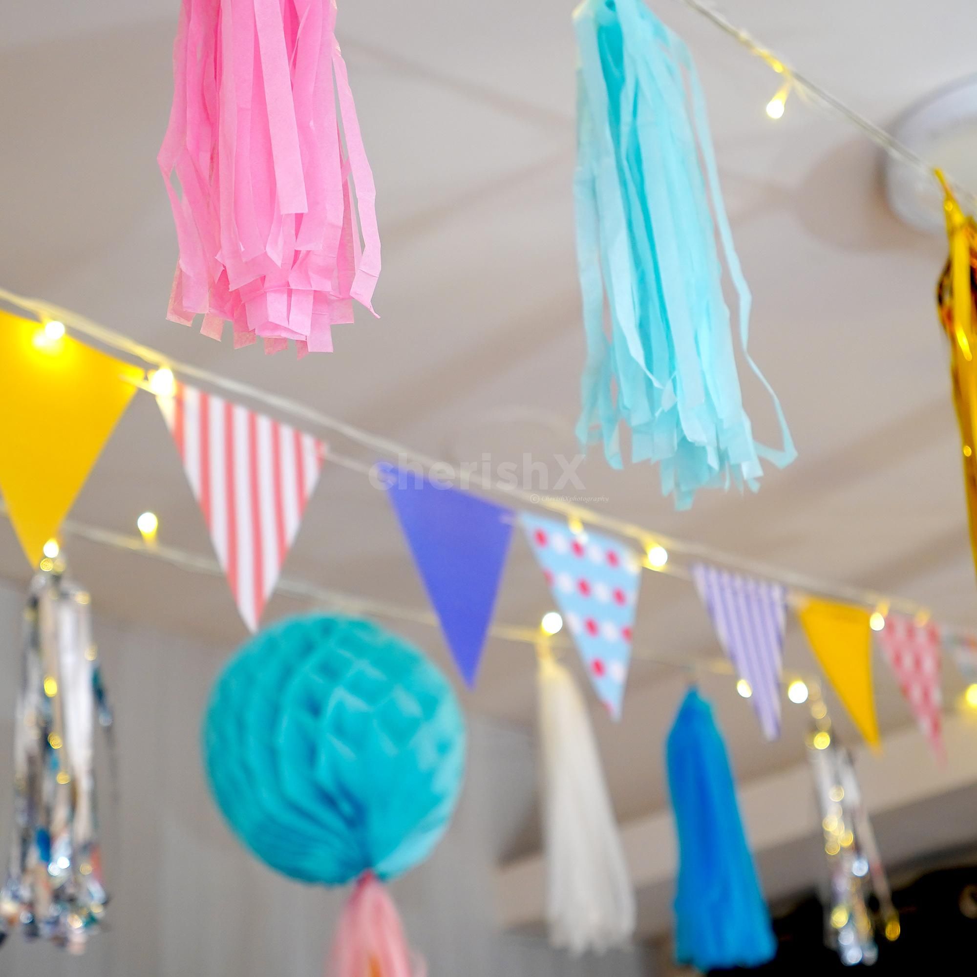 Close-up of colourful honeycomb balls adorned with festive tassels.
