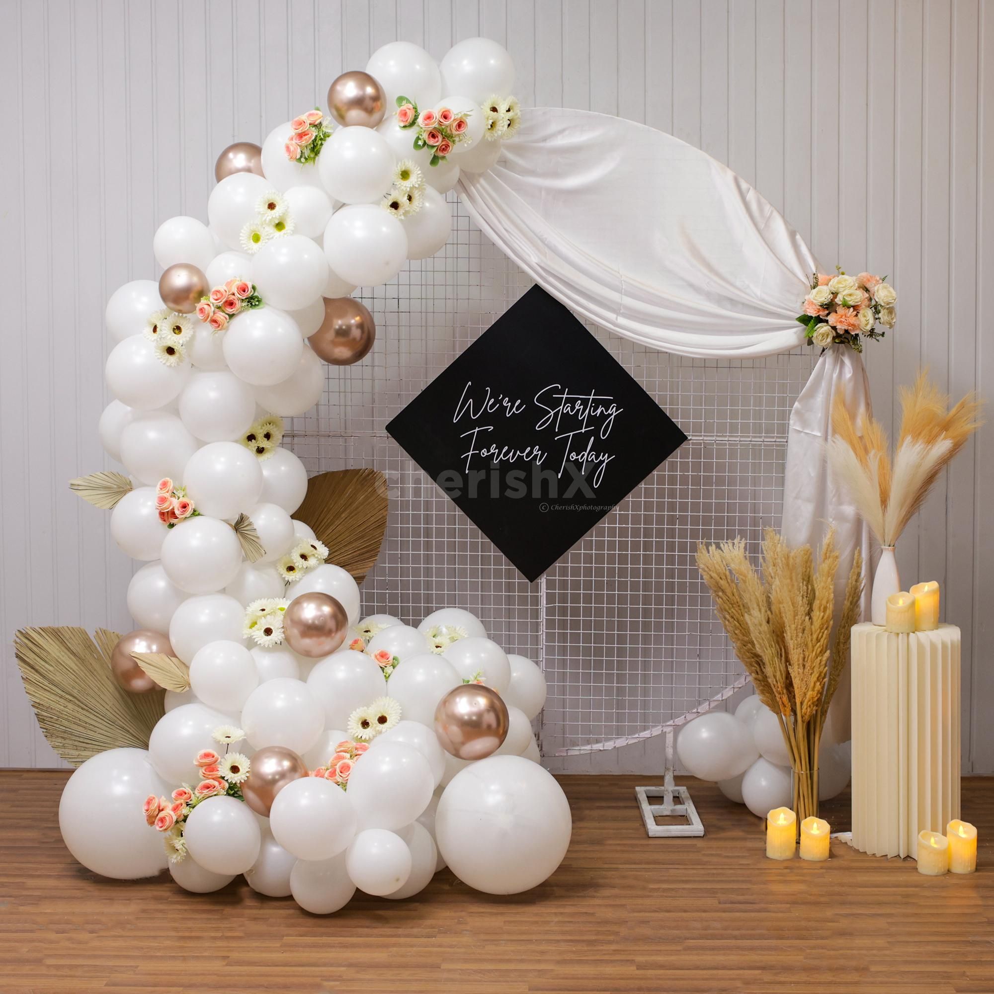 Enhance ambiance with leaves, Champagne and white balloons decor for Engagement