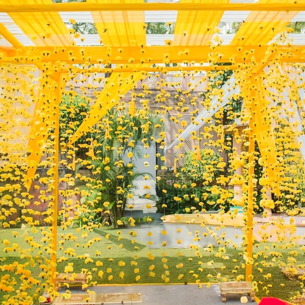 Golden floral mandap brings haldi vibes to life.