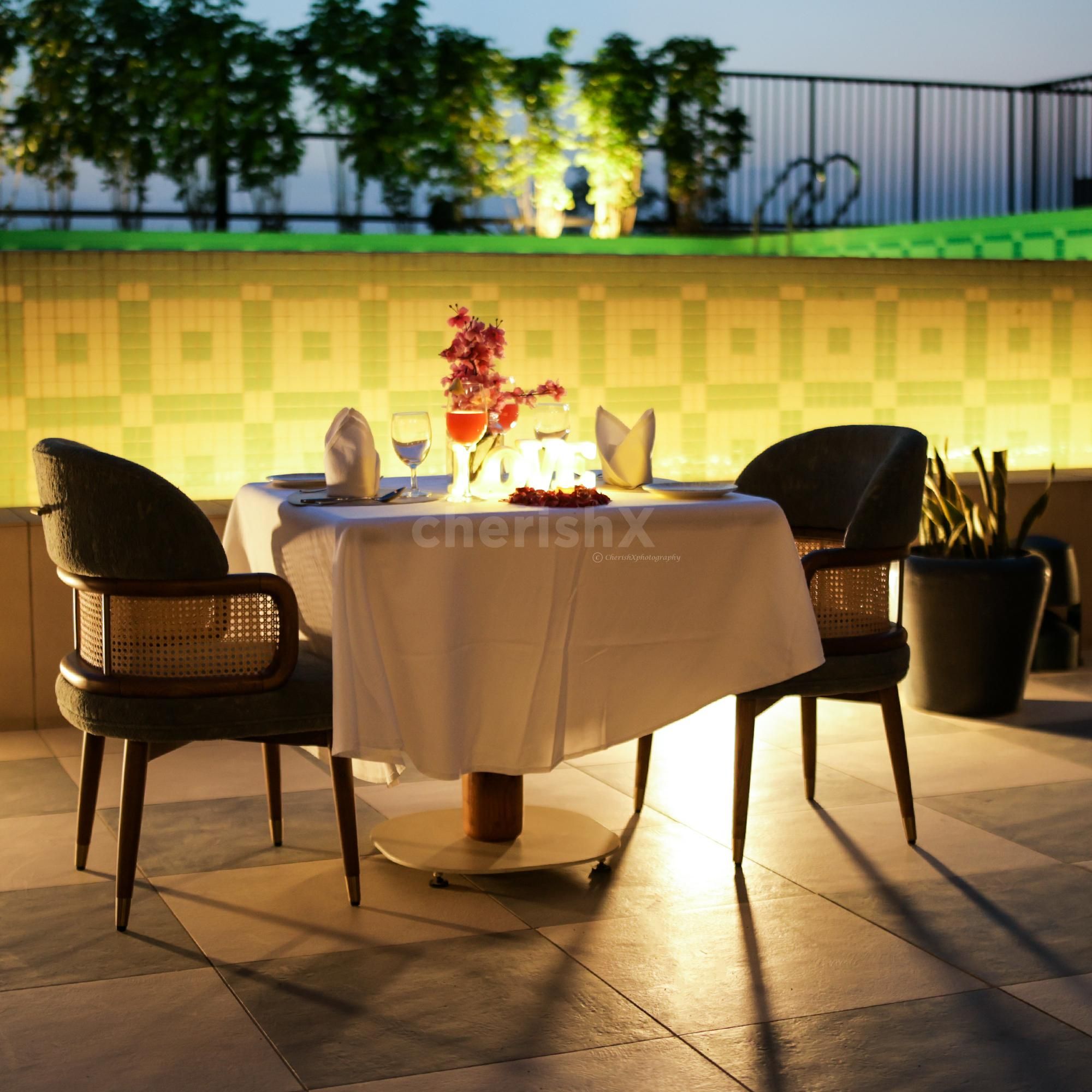 Elegantly decorated table with flowers, lights, and candles on the poolside lower deck.