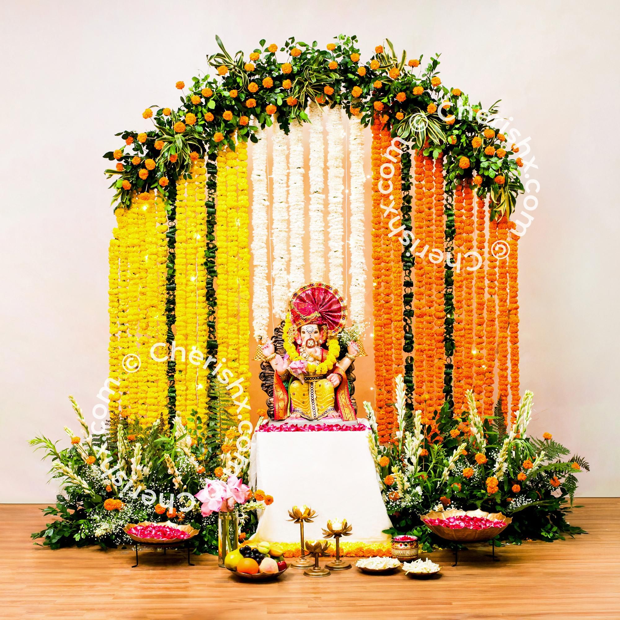 Fairy lights twinkle on marigold backdrop hanging from the circular stand for ganpati decor