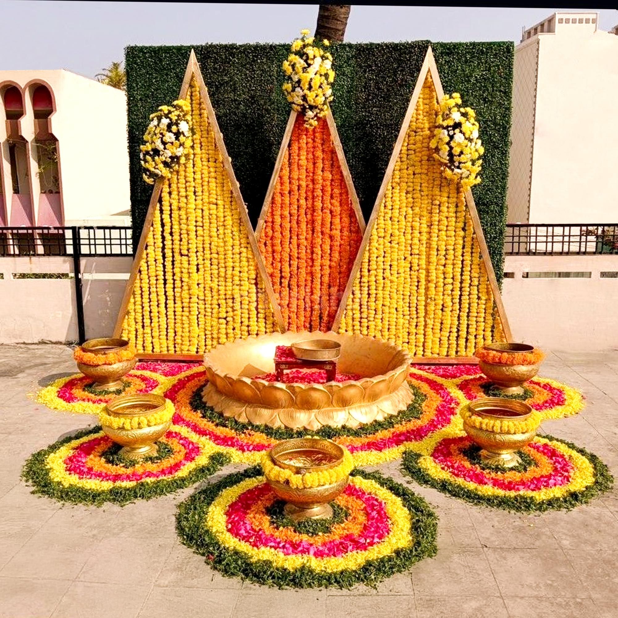 Floral triangle backdrop emitting haldi & mehendi magic.