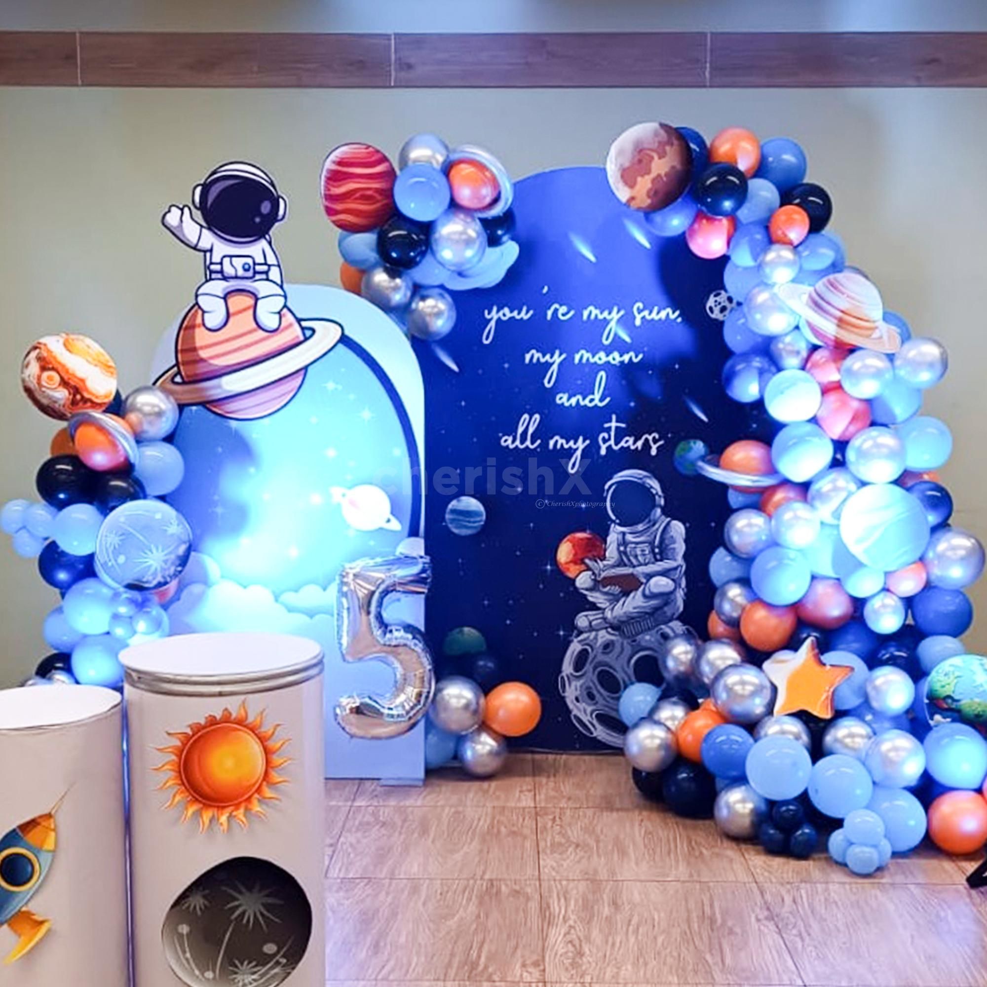 Rocket paper cutouts and age number balloons.