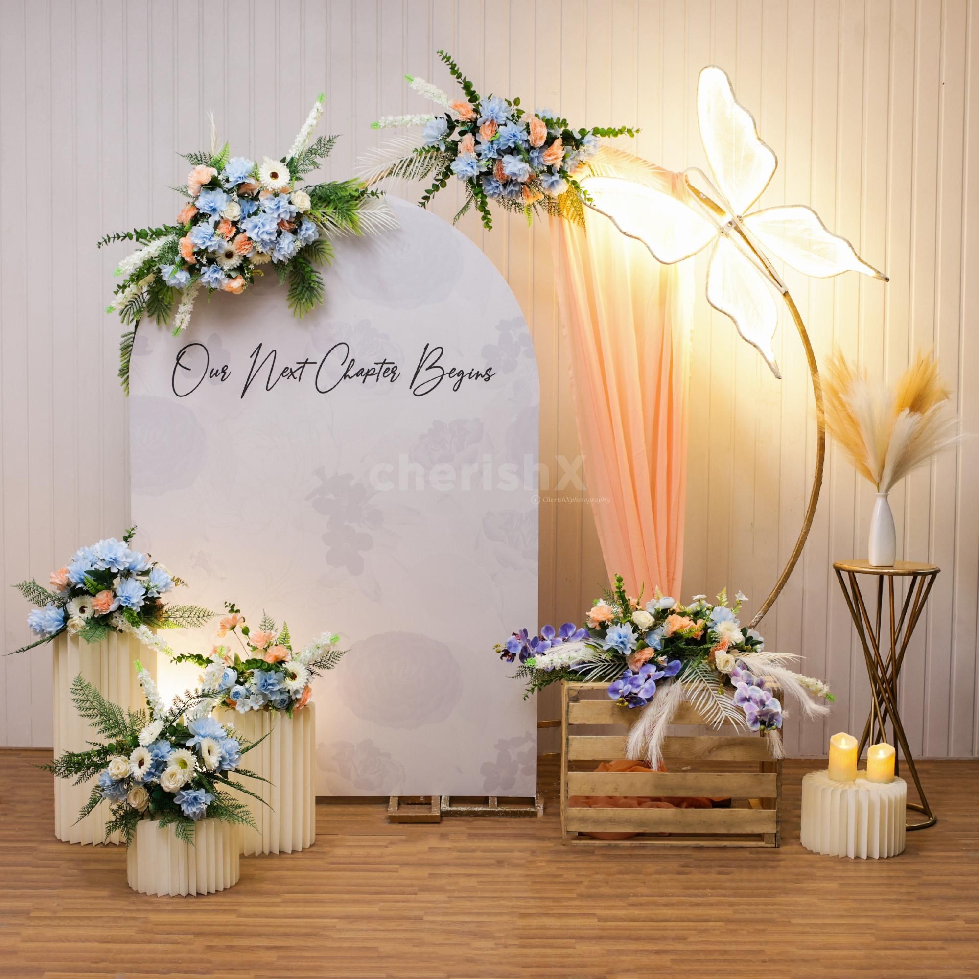 Butterfly along with bunches of artificial flowers creates vibrant engagement decor.